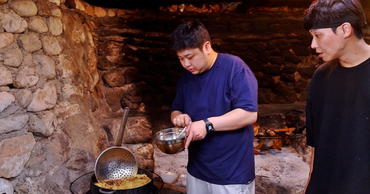 한 남자가 짜장라면을 만들고 있다.
