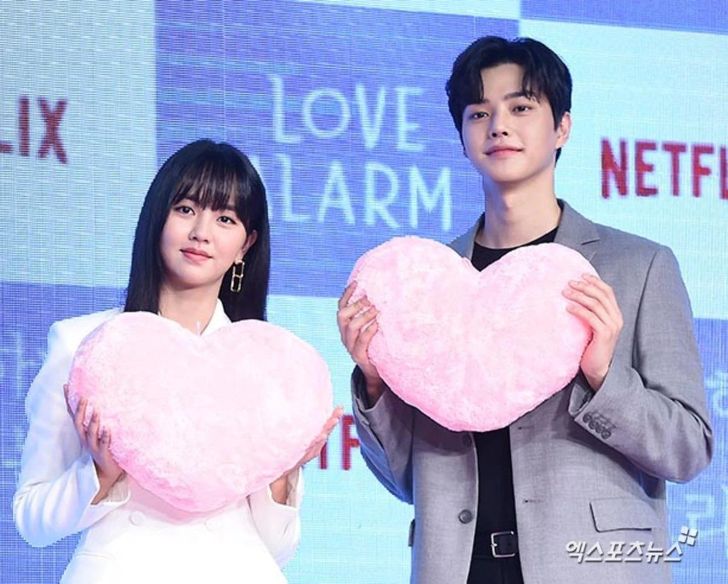 김소현과 송강 배우가 핑크색 하트 쿠션을 들고 있는 모습.