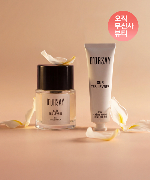 도르세 향수와 핸드크림이 핑크색 배경에 꽃잎과 함께 놓여 있다.