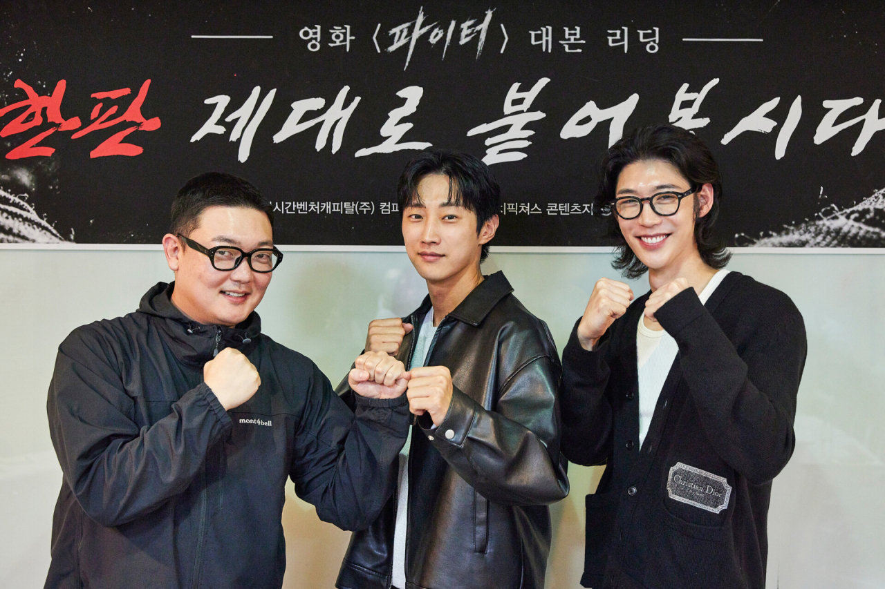 세 남자가 주먹을 쥐고 카메라를 보고 있다.