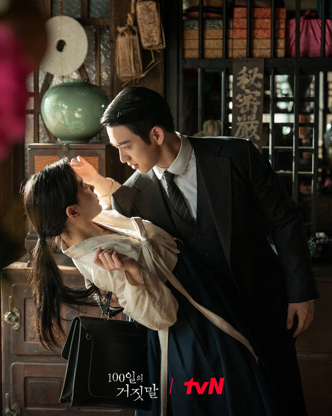 한 남성이 여성을 안고 로맨틱한 분위기를 연출하는 모습.